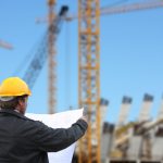 Baukoordinator mit Plan auf einer Baustelle