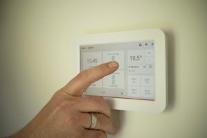 Eine Hand berührt ein modernes Thermostat