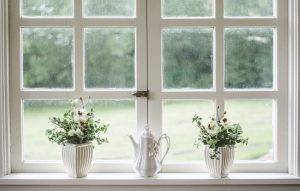 Zwei weiße Fenster mit Blumen auf der Fensterbank