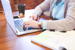 Eine Person arbeitet mit Laptop und Plänen