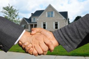 Händeschütteln vor einem Einfamilienhaus