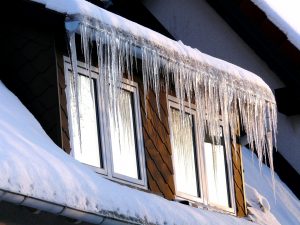 Eiszapfen und Schnee an einem Dach im Winter